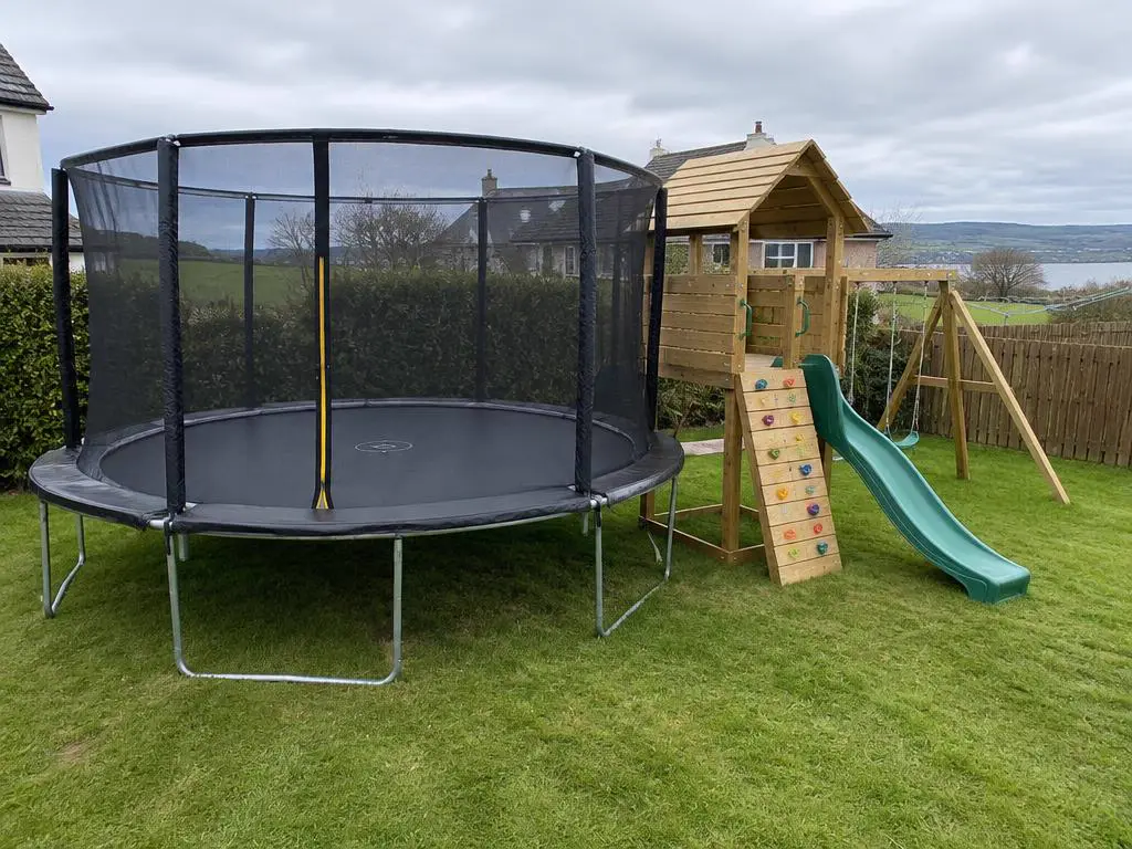 Wooden climbing frame with slide assembled in a family garden in County Armagh